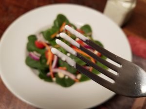 Fork with healthy salad dressing on tines